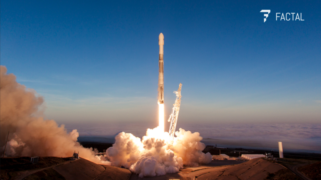SpaceX Iridium-5 rocket launch, as the launch tower falls away and the rocket fuel burns brilliantly from ground to tail. The Factal logo is superimposed at upper right.