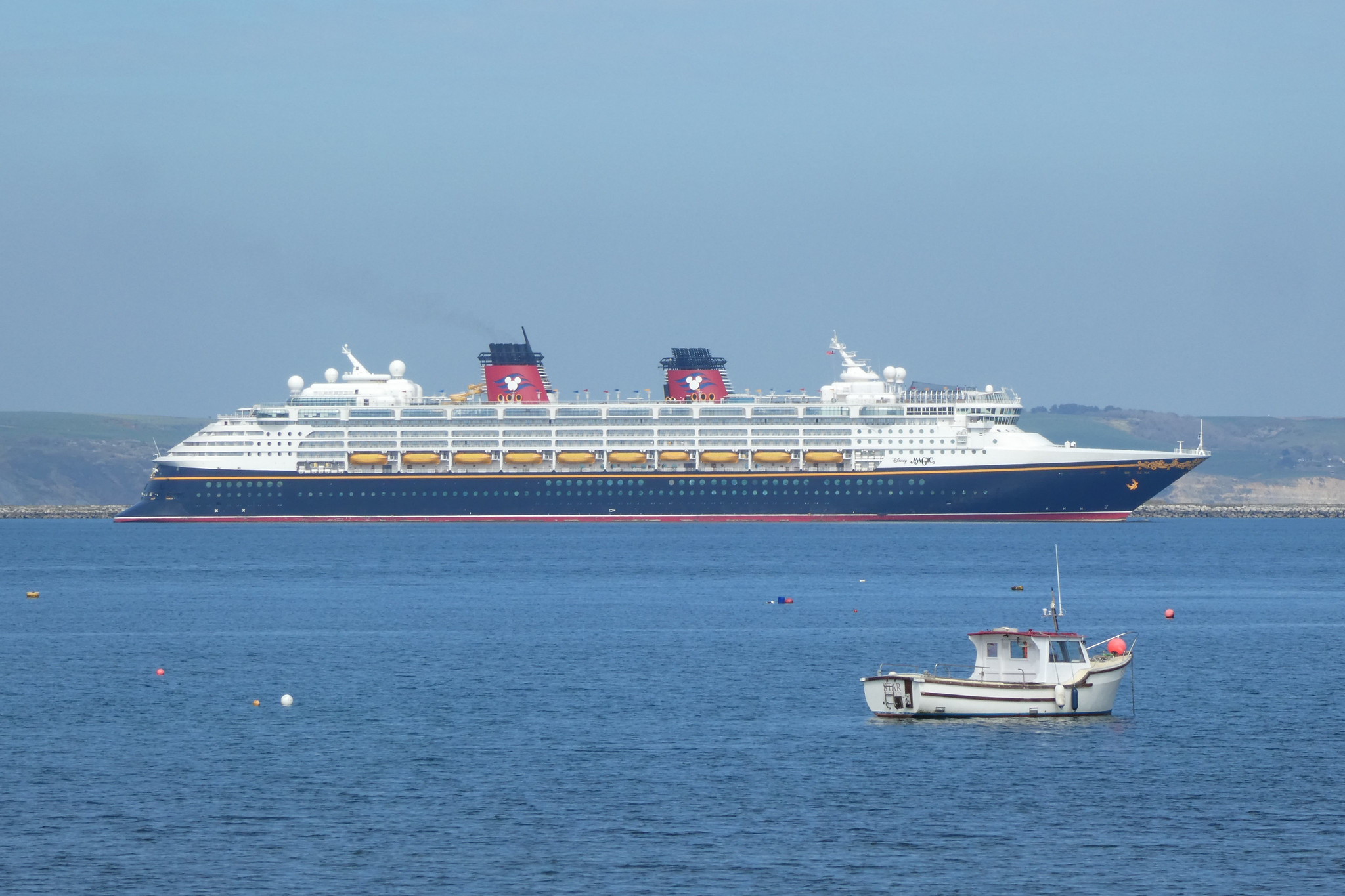 A cruise ship with Mickey Mouse insignia takes up most of the horizon.