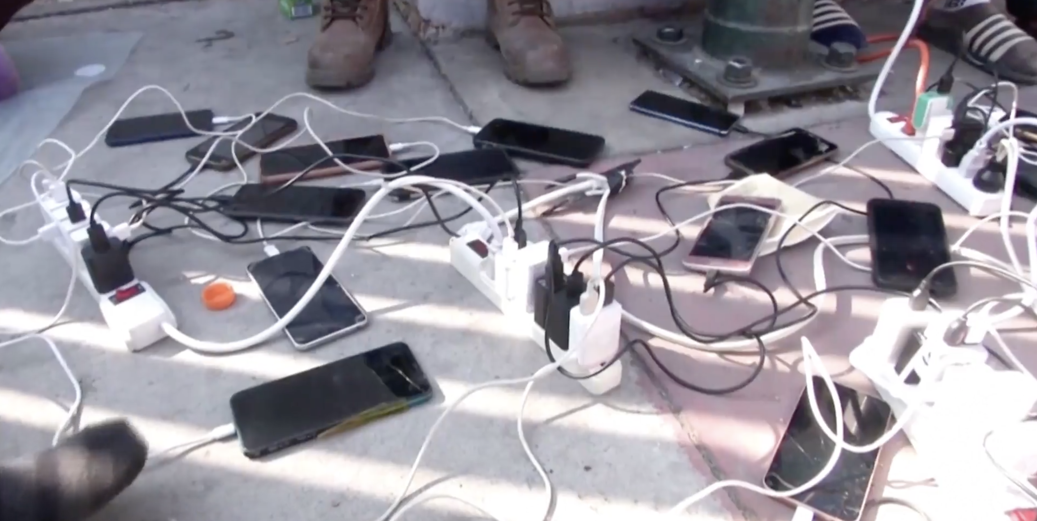 Cell phones charging in a video on the migrant caravan