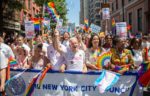 Dozens march in New York City's last in-person Pride March. Almost all are waving rainbow flags, banners and other symbols.