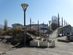 A photo of a bridge along the border of Kosovo and Serbia. The bridge entry is blocked by many ecoblocks, preventing vehicle travel across the bridge.