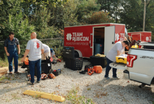 Team Rubicon disaster trailers with a few members in their grey shirts loading and unloading supplies.
