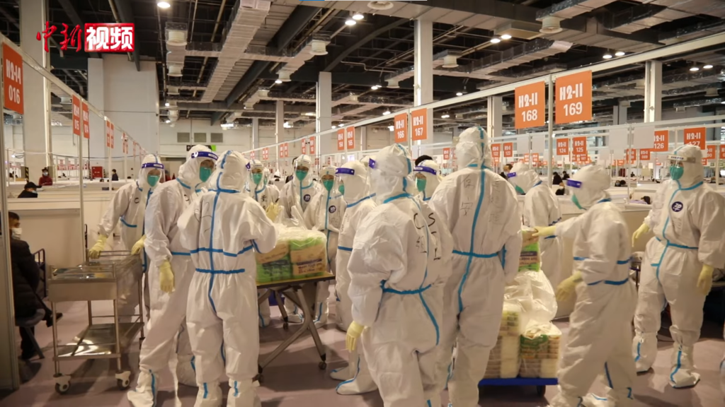 The World Expo Hall in Shanghai is filled with people in protective gear sorting supplies.