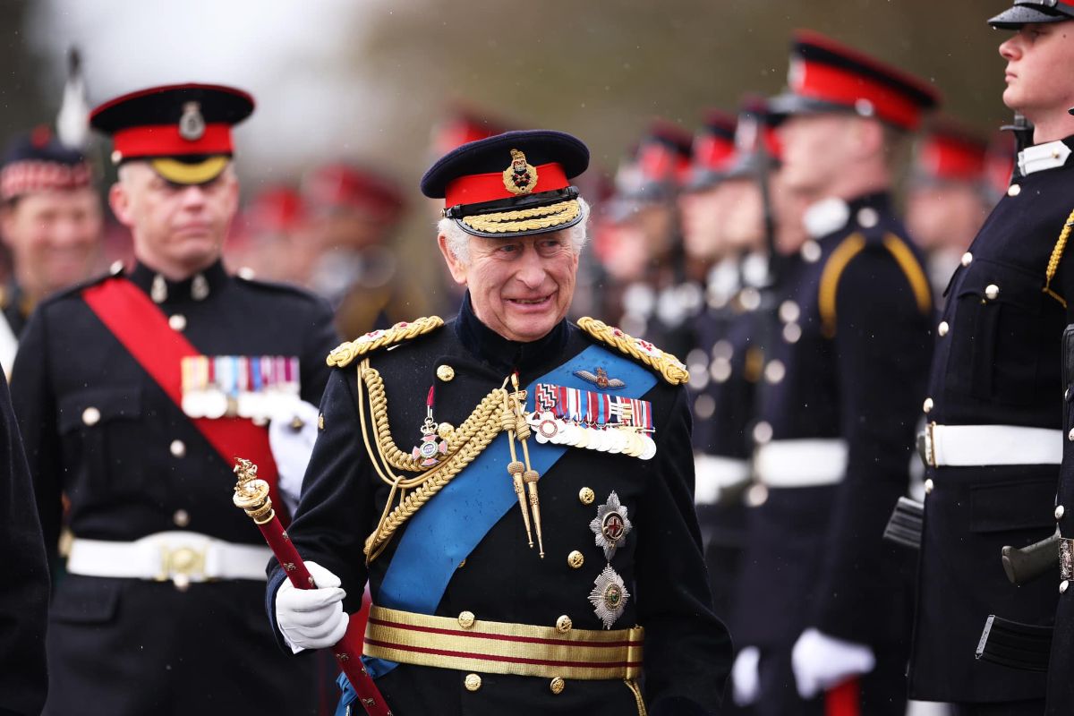 King Charles III in military regalia is flanked by others in formal military uniforms