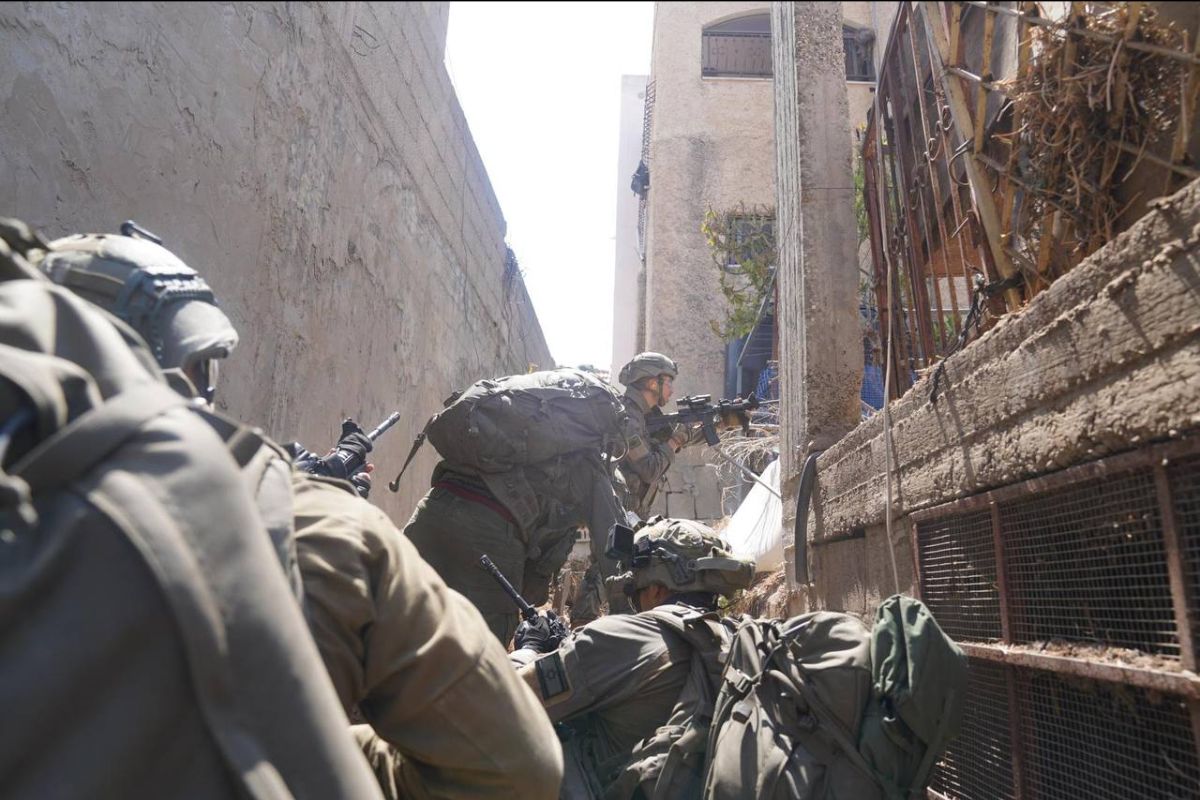 A small squad of soldiers in assault gear in an alley about to enter a backyard or garden
