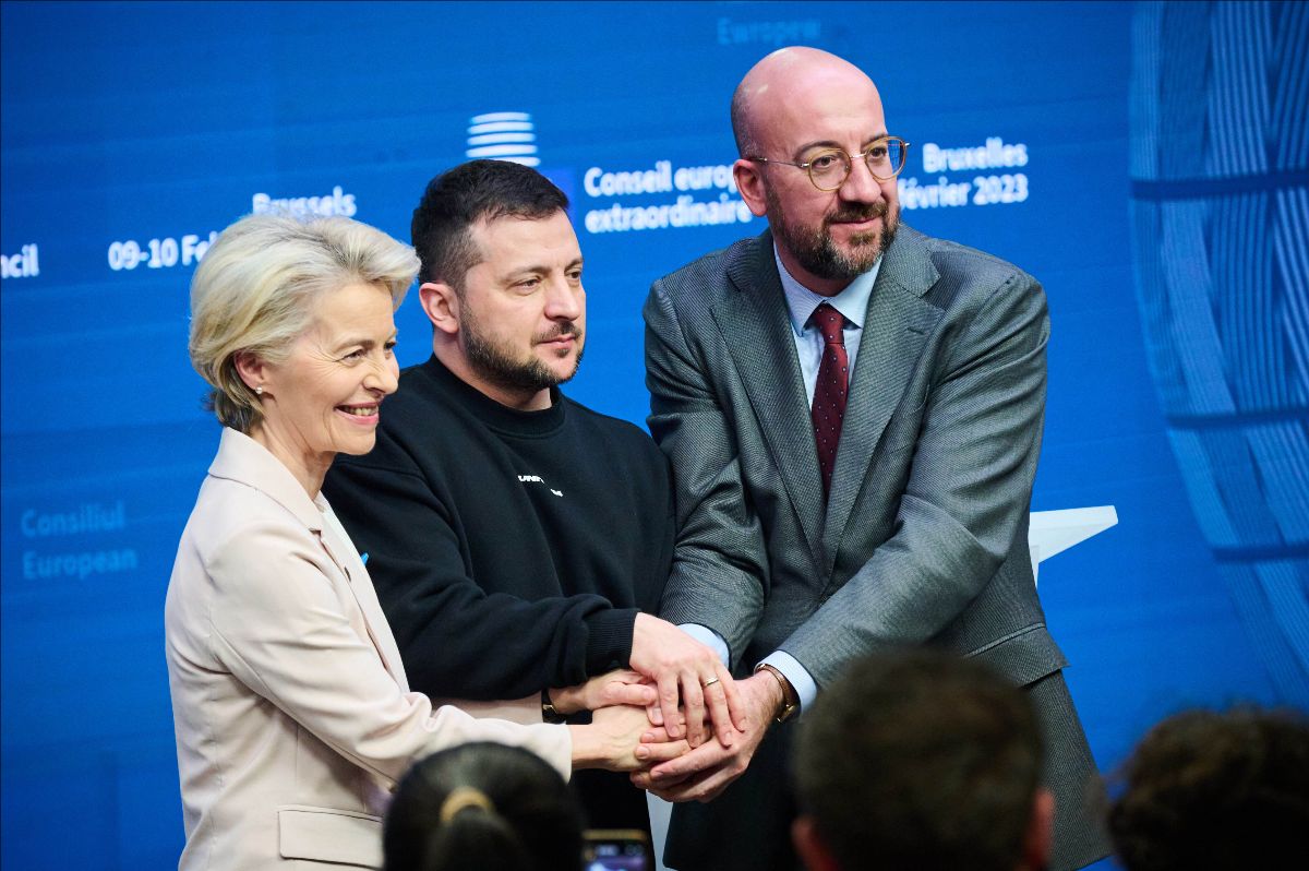 EU President Ursula von der Leyen, Ukrainian President Volodymyr Zelenskyy, and President of the European Council Charles Michel shake hands and smile at cameras following a press conference at the EU summit in Brussels.