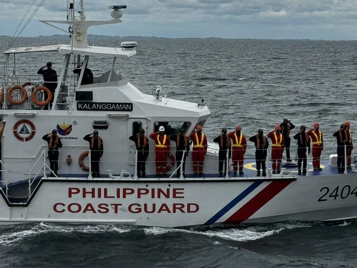 Philippine Coast Guard vessel named Kalanggaman with crew members in uniform saluting on the deck.