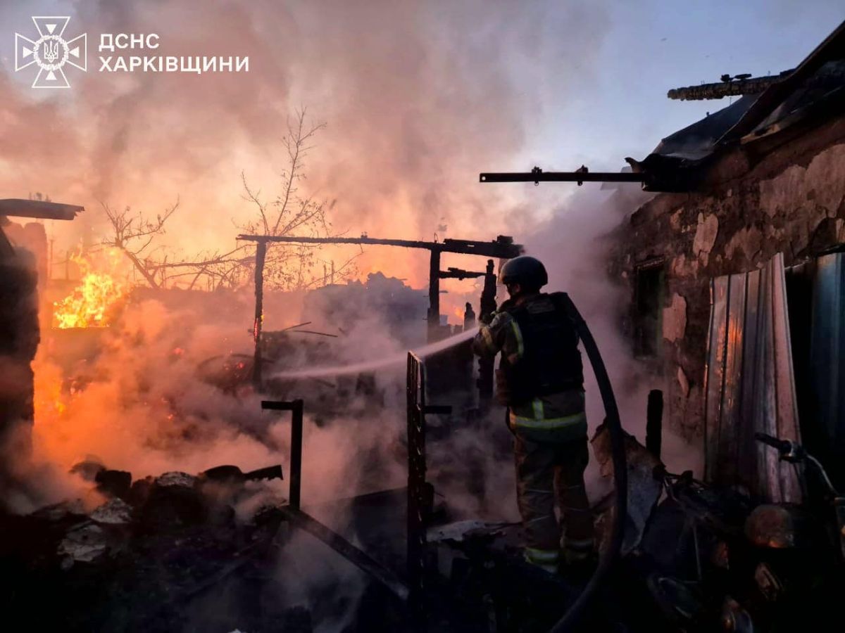 Firefighter extinguishing flames in a partially destroyed structure surrounded by smoke and fire.