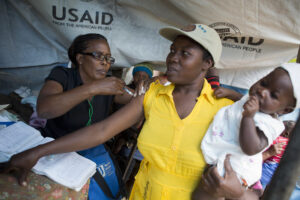 A woman receives a vaccine at a health rally post in Mahotierre-Soisson, Haiti, in 2014.